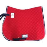 Red quilted horse saddle pad with navy trim and attached tags