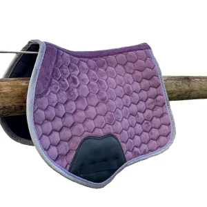Purple hexagonal quilted horse saddle pad hanging on a wooden rail